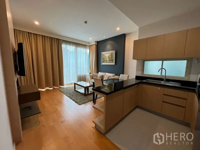 Condominium for rent in Chatuchak, Bangkok - Open-plan kitchen and living area with floor-to-ceiling curtains and wood floors