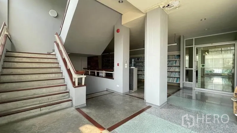 Warehouse for sale in Bangkok Yai, Bangkok - Lobby with staircase, built‑in shelving and glass entry doors.