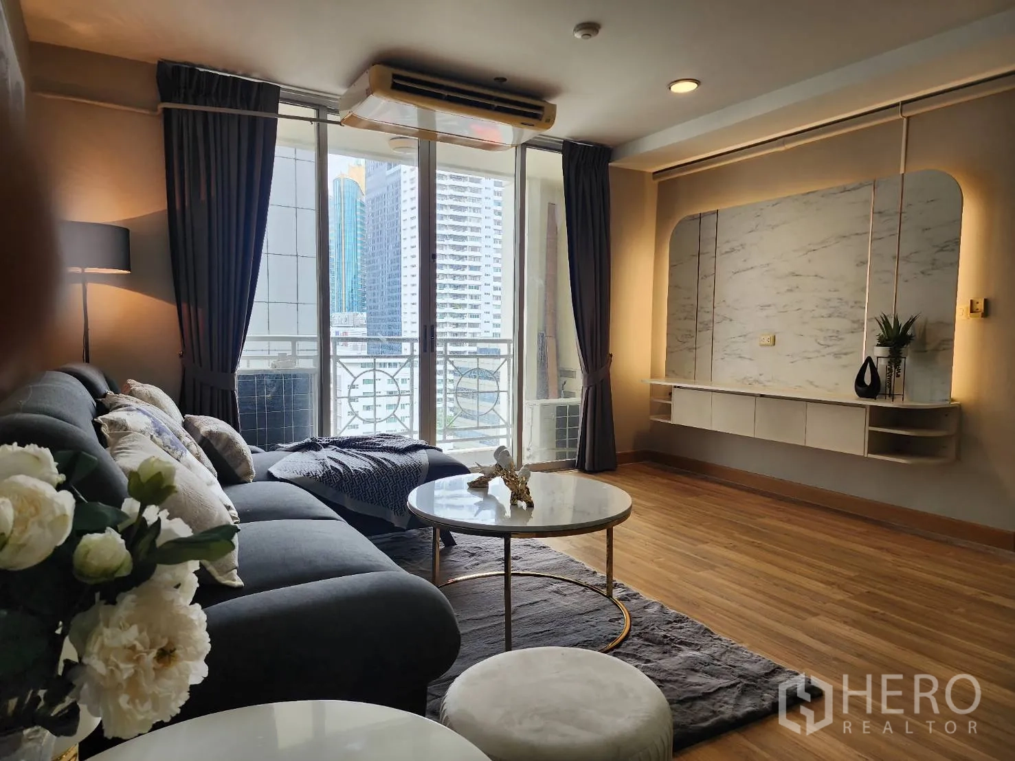 公寓 for rent in Watthana, Bangkok - 客厅面向玻璃推拉门与带灯带的电视背景墙。