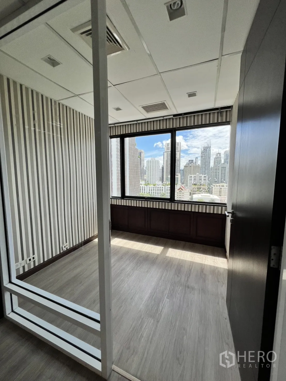 Office Space for rent in Watthana, Bangkok - Compact private office with large window and city skyline view.
