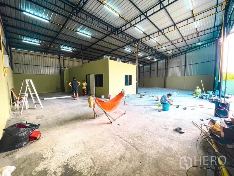 货栈 出租在Sai Mai, Bangkok - 开敞式仓库内部，中央办公室盒体与宽阔装卸入口。