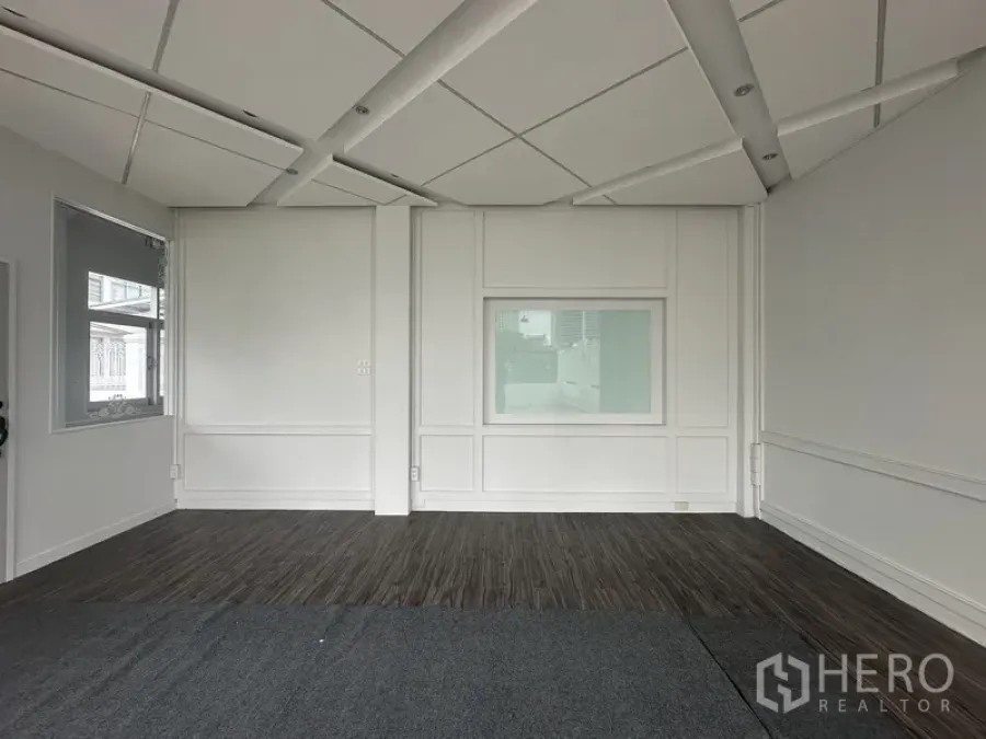 Retail Space for rent in Bang Rak, Bangkok - Bright interior retail room with paneled white walls, dark wood flooring, and geometric ceiling.