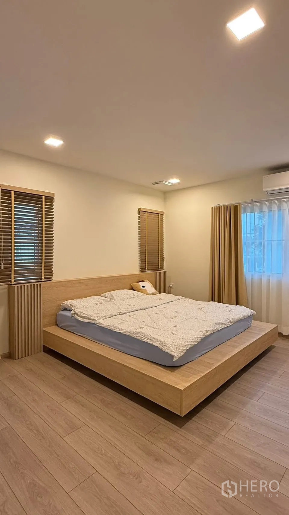 Detached House for rent in Bang Phli, Samut Prakan - Master bedroom with platform bed, wood floors, blinds and air conditioning.
