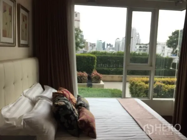 คอนโด ให้เช่าหรือขายในWatthana, Bangkok - ห้องนอนมีหน้าต่างบานใหญ่เปิดออกสู่เทอเรซสวนและวิวเมืองไกล ๆ