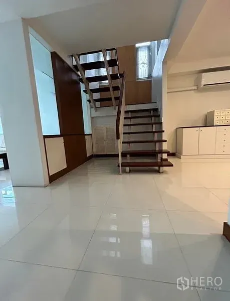 带办公室的家 出租在Suan Luang, Bangkok - 入口大厅，悬浮木楼梯与亮面瓷砖地面