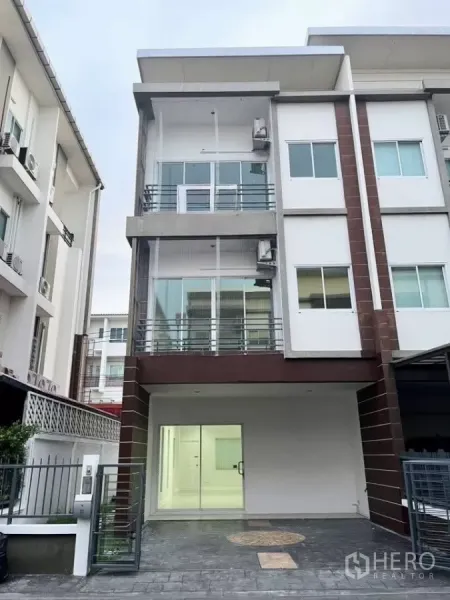 带办公室的家 出租在Bueng Kum, Bangkok - 三层转角式居家办公楼外观，带有车棚与玻璃门面