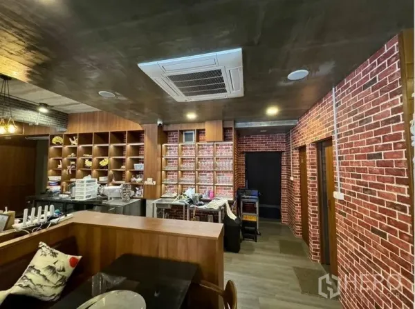 Shophouse for rent in Watthana, Bangkok - Interior with brick feature walls, built-in shelving and a ceiling cassette air conditioner.