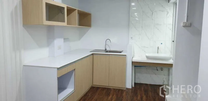 带办公室的家 出租或出售在Suan Luang, Bangkok - 茶水间，白色台面、木柜与旁侧洗手台。