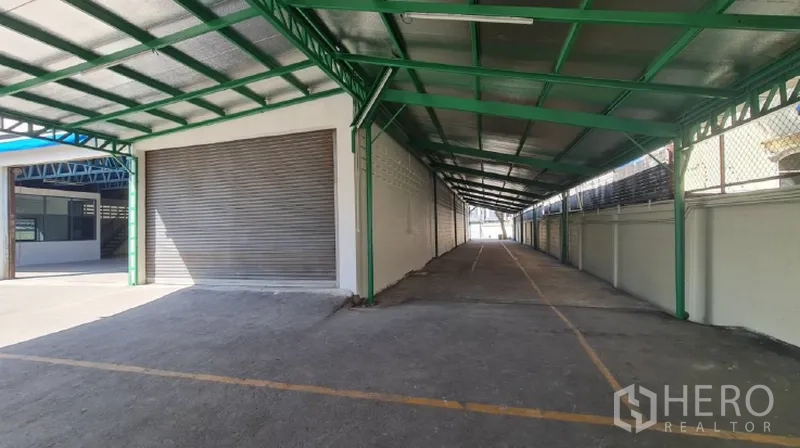 Warehouse for rent in Khlong Toei, Bangkok - Roller shutter doors opening to a covered loading and parking area.