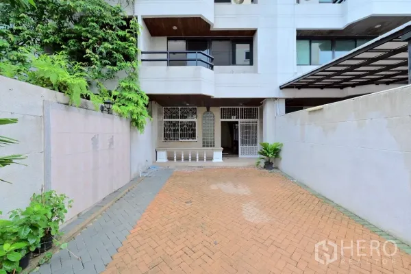 联排别墅 出售在Watthana, Bangkok - 联排别墅外立面，带栅栏车道与小型前庭。
