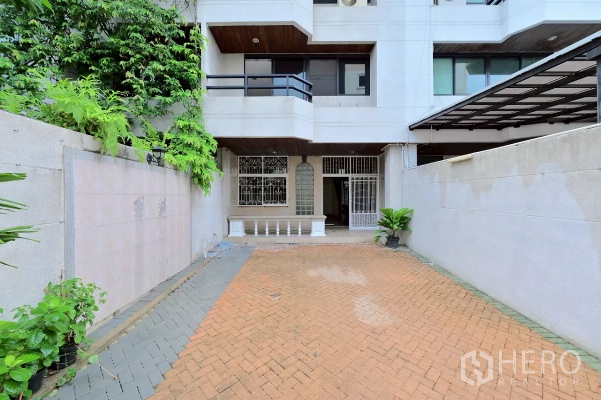 联排别墅 出售在Watthana, Bangkok - 联排别墅外立面，带栅栏车道与小型前庭。