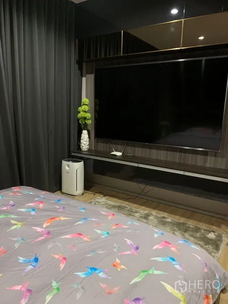 带办公室的家 出租在Saphan Sung, Bangkok - 主卧影音墙，超大电视、深色窗帘与木质细节。