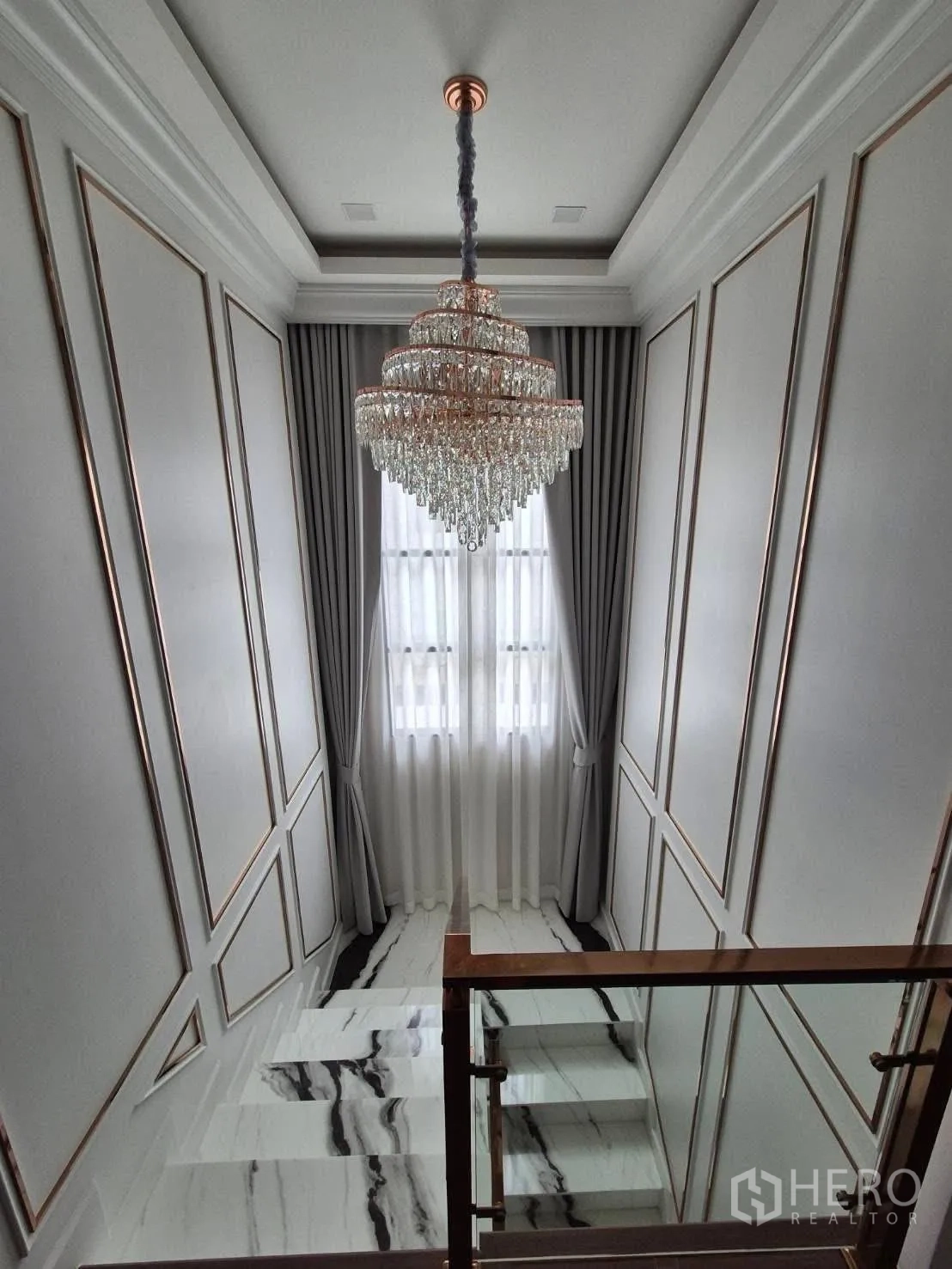 Detached House for sale in Bang Kruai, Nonthaburi - Stairwell with tiered crystal chandelier, tall window and marble steps.