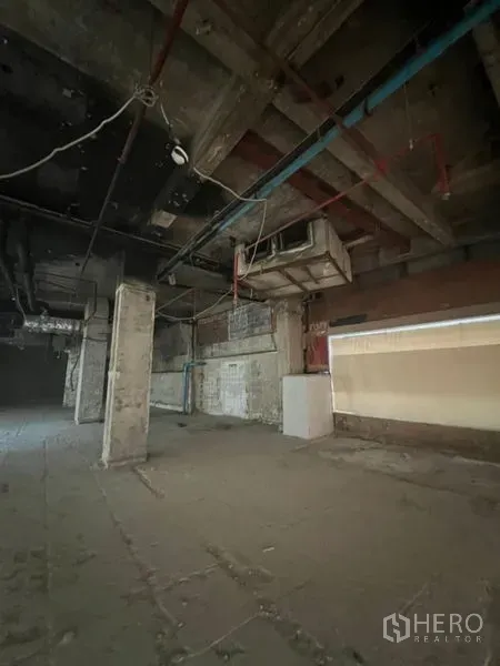 Retail Space for rent in Bang Rak, Bangkok - Open-plan shop space showing exposed pipes, columns, and high ceilings.