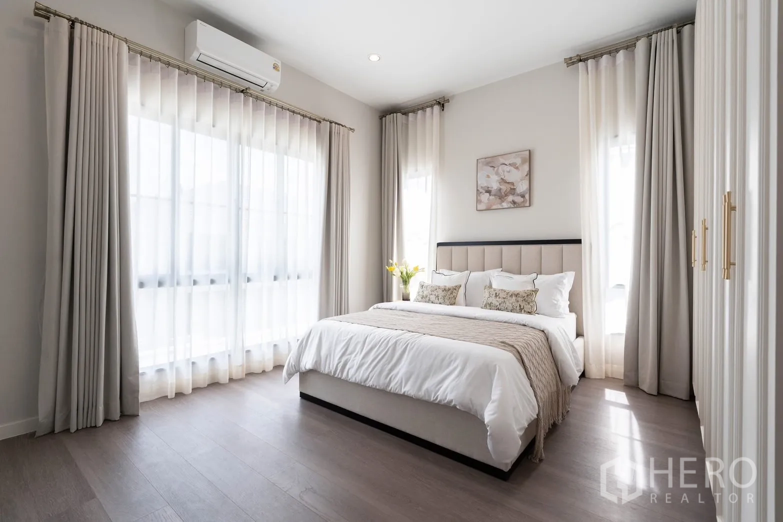 Detached House for rent in Bang Phli, Samut Prakan - Sunlit guest bedroom with king bed, wall AC, and full-height curtains.