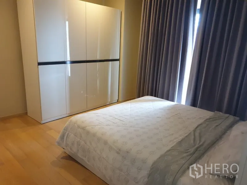 公寓 出租在Watthana, Bangkok - 温馨卧室，双人床、亮面大衣柜与遮光窗帘。