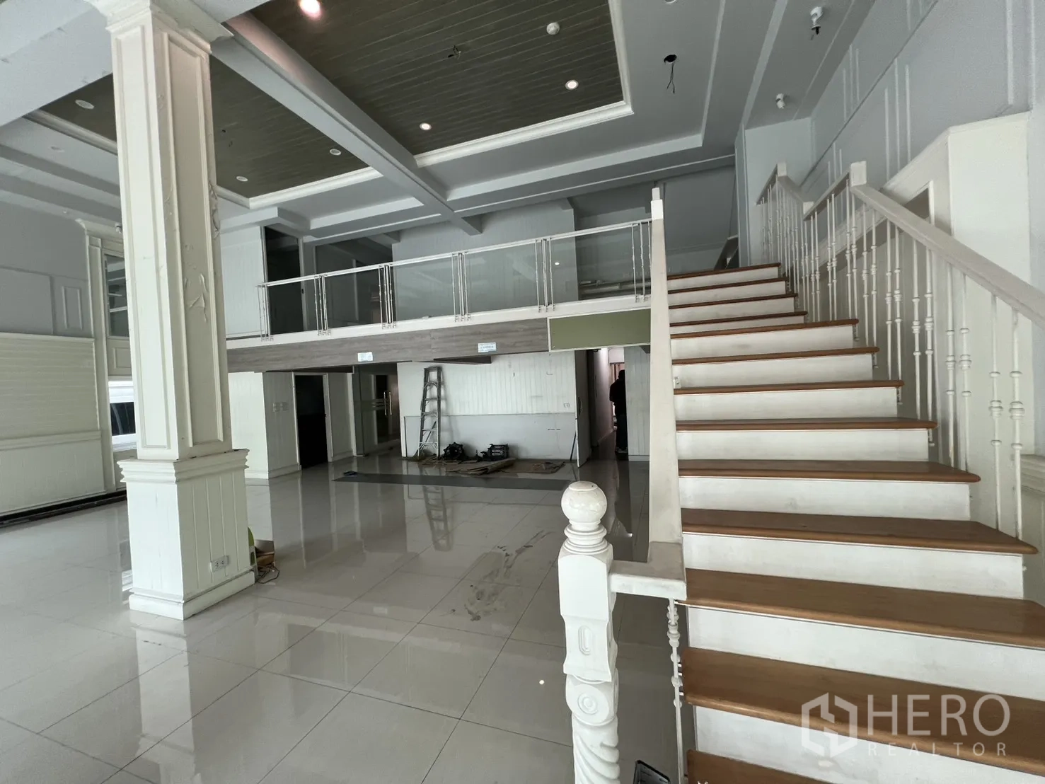 Shophouse for rent in Bang Rak, Bangkok - Feature staircase leading to a mezzanine overlooking the open retail floor.