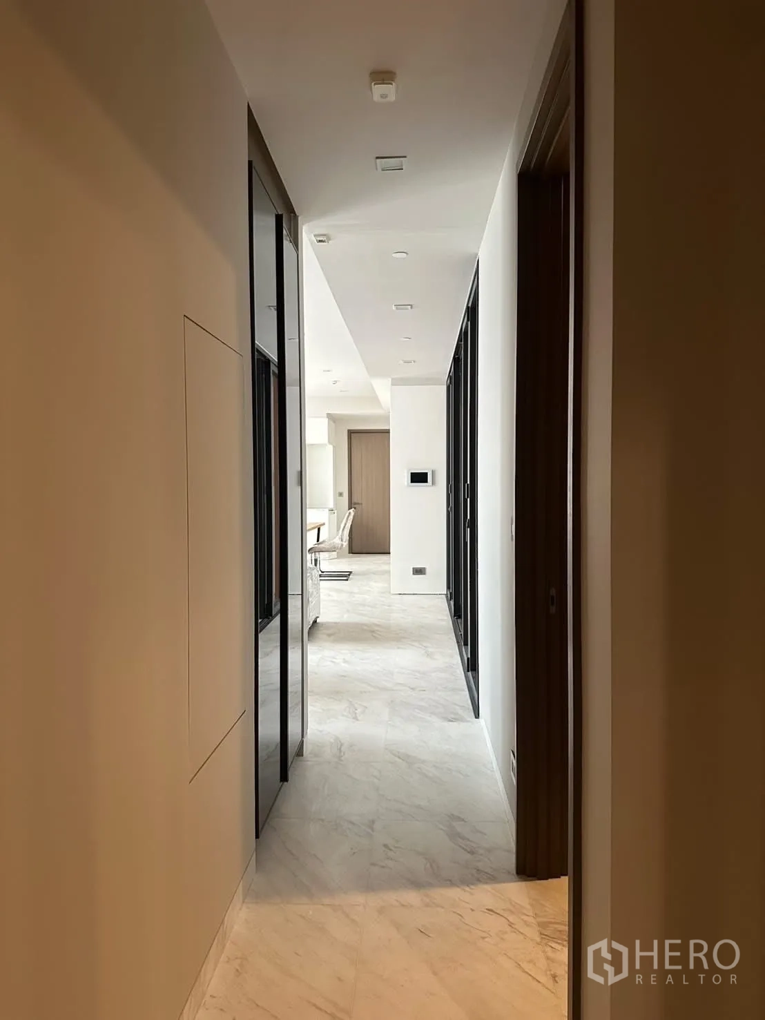 คอนโด for rent or sale in Watthana, Bangkok - โถงทางเดินยาวพร้อมไฟดาวน์ไลท์และพื้นลายหินอ่อน.