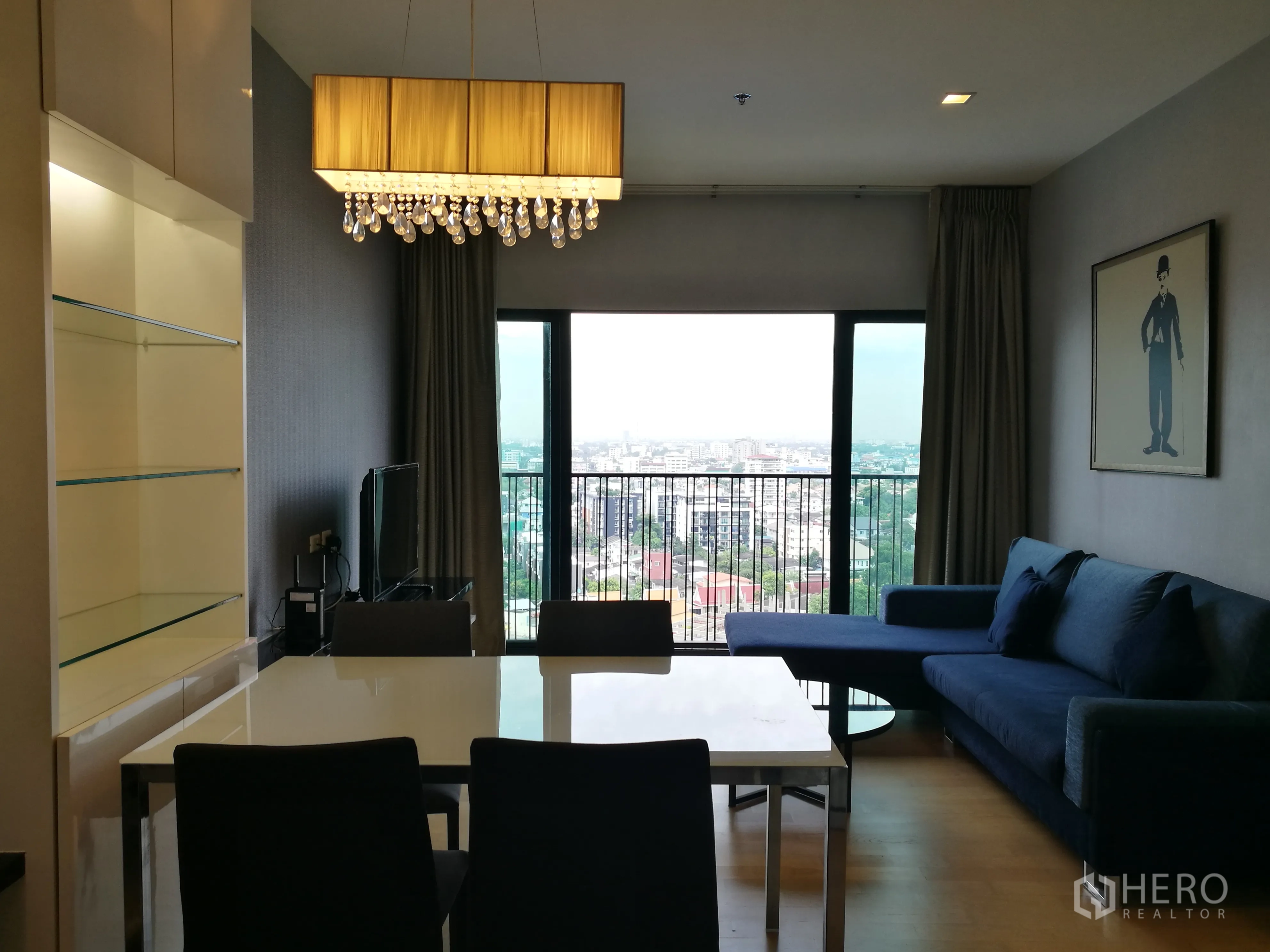 คอนโด for rent in Watthana, Bangkok - พื้นที่นั่งเล่นและรับประทานอาหารแบบโอเพ่นแพลน โคมแชนเดอเลียร์ ชั้นโชว์กระจก ชุดโต๊ะอาหาร และประตูระเบียงมุมมองเมือง