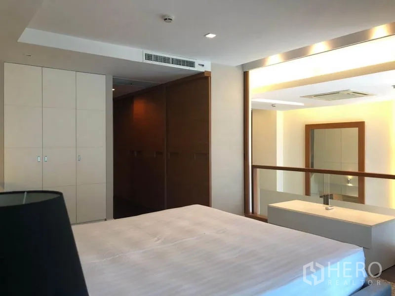 公寓 出租在Pathum Wan, Bangkok - 主卧带内置衣柜与玻璃隔断，可俯瞰客厅区域。