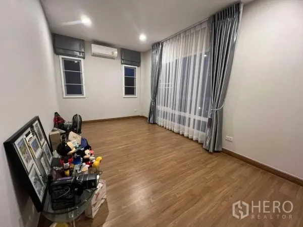 独立式住宅 出租或出售在Lat Krabang, Bangkok - 卧室铺木地板，分体空调与落地窗帘。
