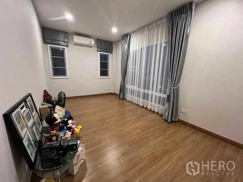 独立式住宅 出租或出售在Lat Krabang, Bangkok - 卧室铺木地板，分体空调与落地窗帘。