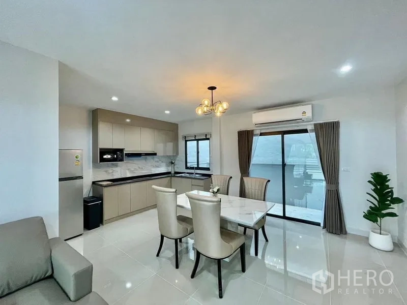联排别墅 出租在Bang Phli, Samut Prakan - 餐厨空间配吊灯与推拉门，绿色盆栽增添清新感。