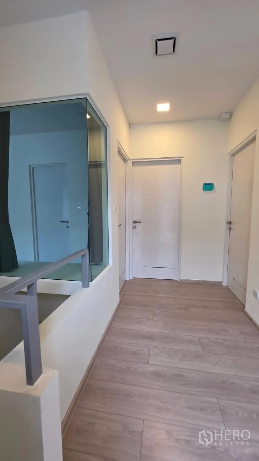 独栋房屋 for rent in Bang Phli, Samut Prakan - 二楼走廊，玻璃隔断与多扇房门，木纹地板。