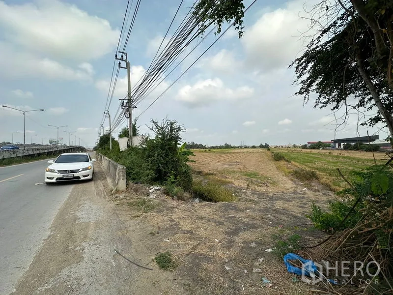 ที่ดิน ขายในBang Bua Thong, Nonthaburi - ทางเข้าแปลงที่ดินกว้างขวาง ติดถนนลาดยาง มีเสาไฟและร่องระบายน้ำ เหมาะพัฒนาโครงการ