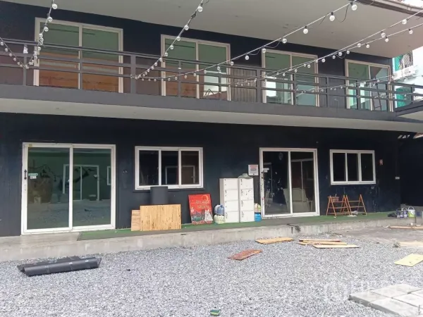 零售空间 出租在Huai Khwang, Bangkok - 一层店面近景，上层阳台与串灯装饰立面。