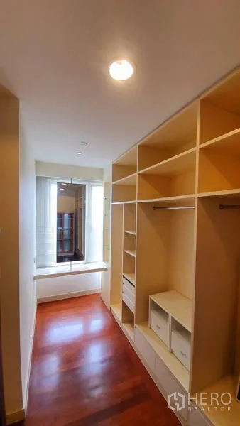 Condominium for rent in Watthana, Bangkok - Walk‑in closet with built‑in shelving and a window bench overlooking the city.