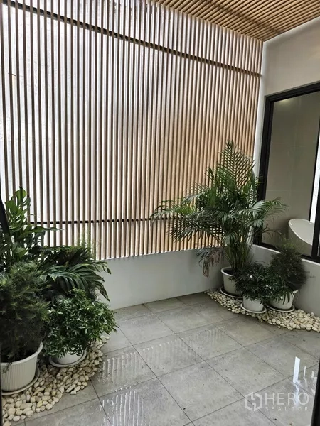 独立式住宅 出售在Khlong Toei, Bangkok - 带顶露台，垂直格栅与盆栽绿植点缀。