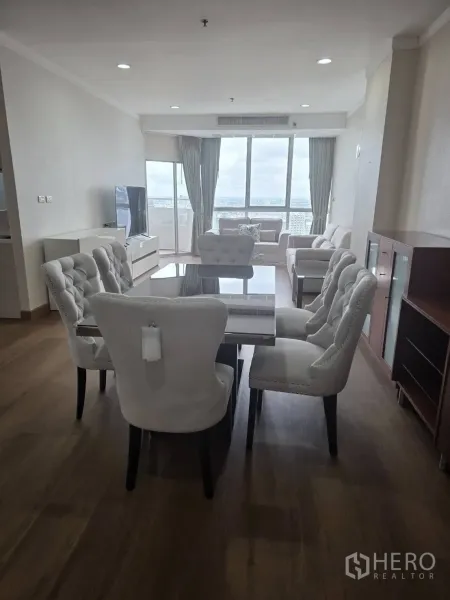 Condominium for rent in Khlong Toei, Bangkok - Open living–dining space facing large windows with expansive city views.