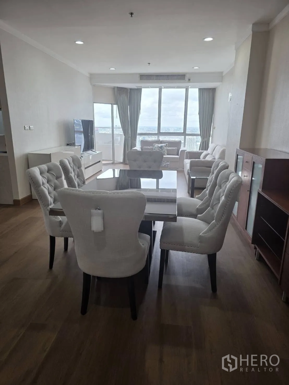 Condominium for rent in Khlong Toei, Bangkok - Open living–dining space facing large windows with expansive city views.