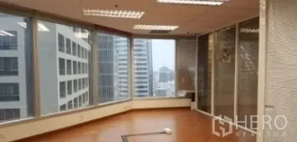 办公空间 出租在Bang Rak, Bangkok - 转角办公室，落地窗环绕，木地板，俯瞰曼谷城市天际线。