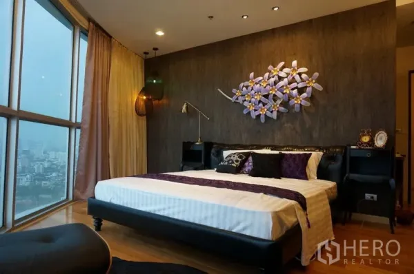 公寓 出租在Watthana, Bangkok - 主卧带城市景观窗，墙面装饰艺术与氛围灯，配大床。