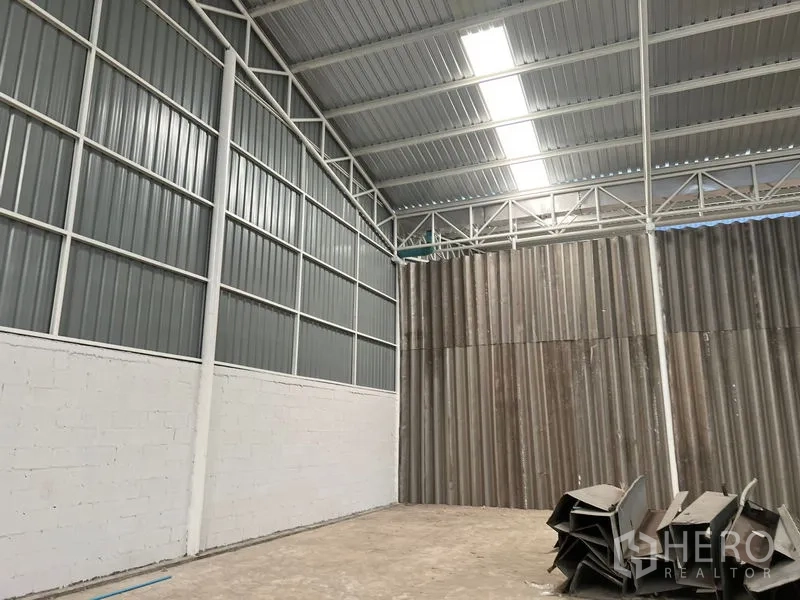 Warehouse for rent in Min Buri, Bangkok - Corner of warehouse highlighting tall insulated walls and roof skylight strip.