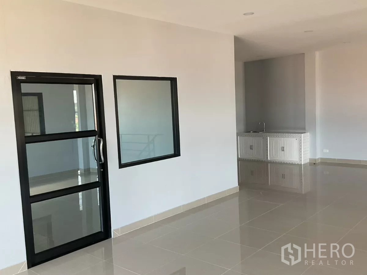 Factory for sale in Samut Sakhon - Office area with pantry and glass door, featuring polished tile flooring.