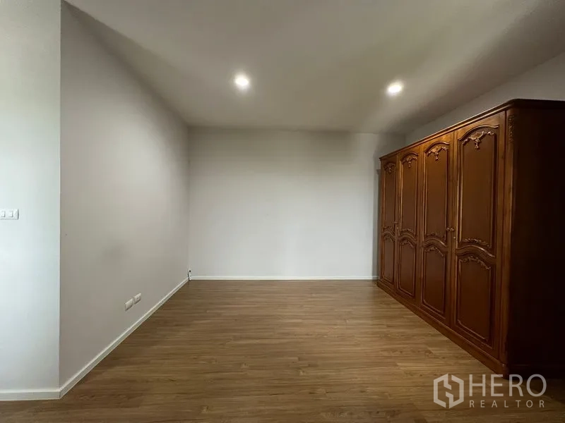 Detached House for rent in Saphan Sung, Bangkok - Another angle of the large bedroom with ornate wooden wardrobe and recessed lights.