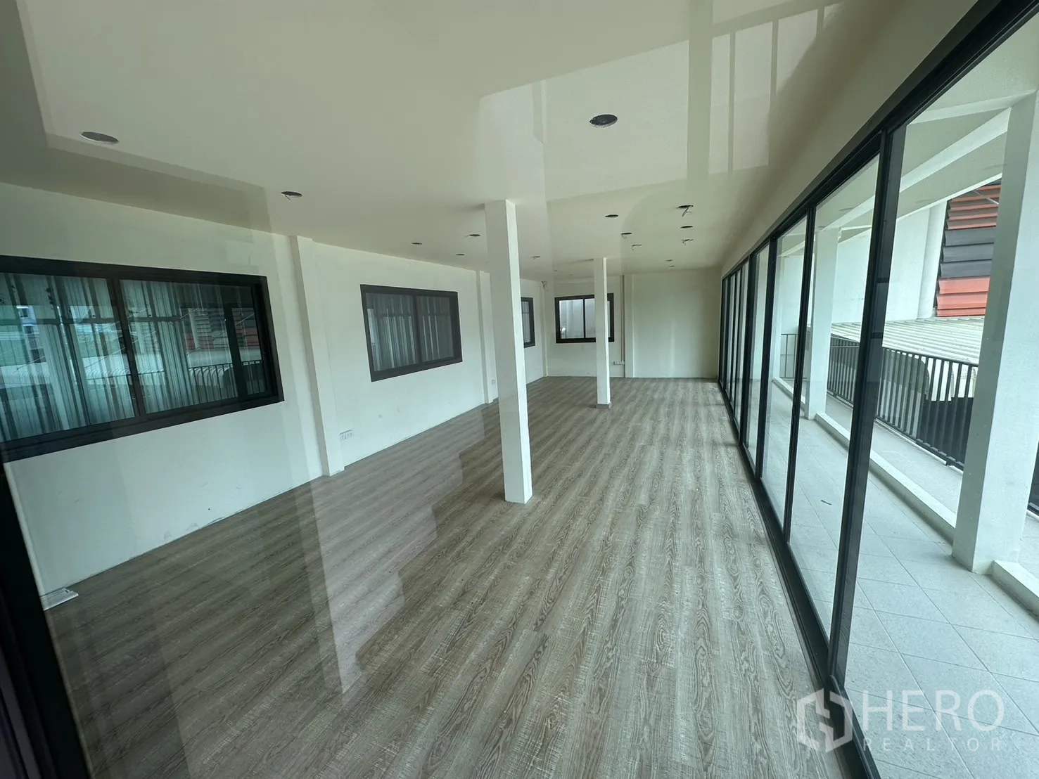 Warehouse for rent in Suan Luang, Bangkok - Glass-walled upper office area with wood-look flooring and abundant light.