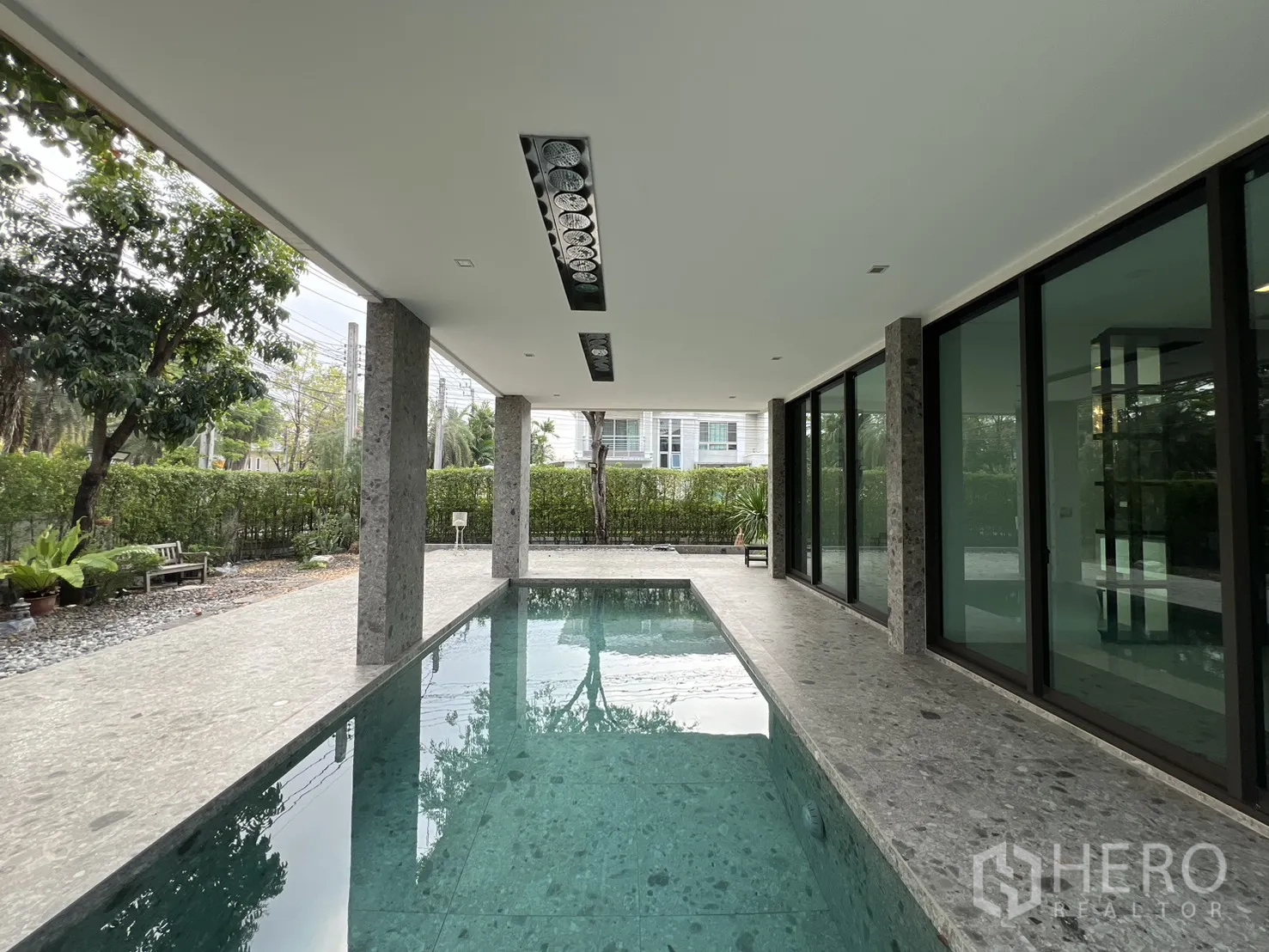 บ้านเดี่ยว for rent in Prawet, Bangkok - สระว่ายน้ำทรงยาวรายล้อมด้วยเสาหินและแนวไม้พุ่มสีเขียว