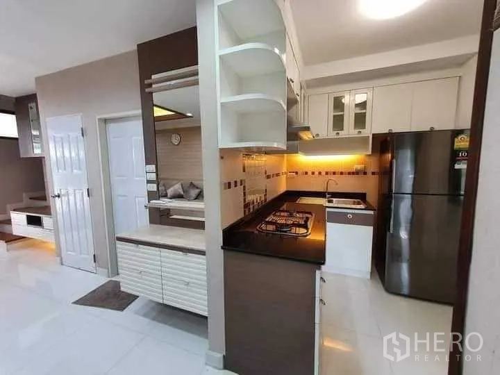 联排别墅 出租在Phra Khanong, Bangkok - 厨房视角，背墙灯带、燃气灶与充足橱柜收纳。