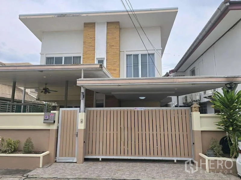 Townhouse for rent in Chatuchak, Bangkok - Modern townhouse facade with gated carport and sliding entry gate.