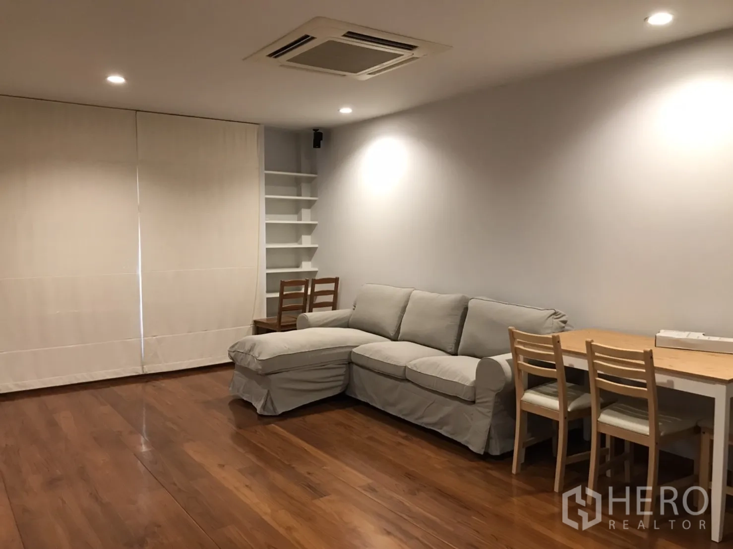 Detached House for rent in Wang Thonglang, Bangkok - Bright living room with wood floors, recessed lighting, L-shaped sofa and dining corner