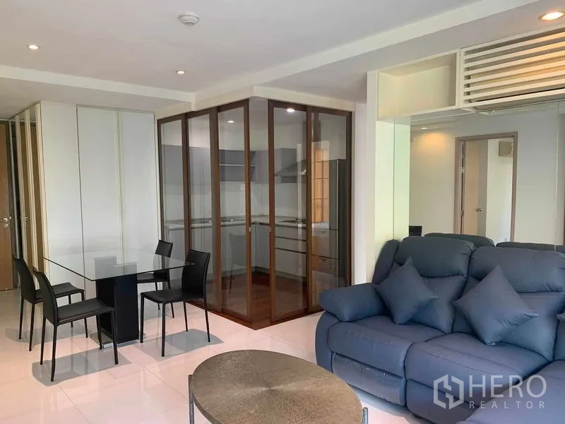 Condominium for rent or sale in Khlong Toei, Bangkok - Close view of living area with glass dining table beside the enclosed kitchen.