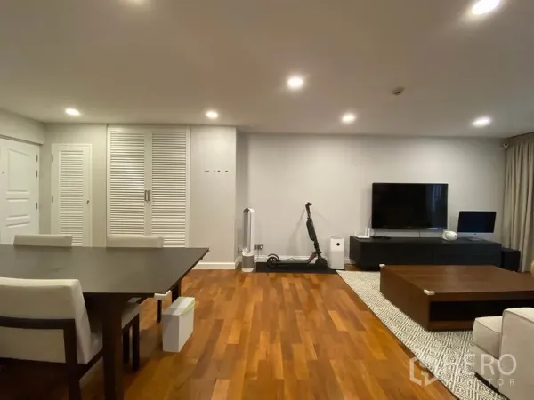 公寓 出租或出售在Watthana, Bangkok - 影音墙配平板电视与收纳柜，旁连餐区，温润木地板。