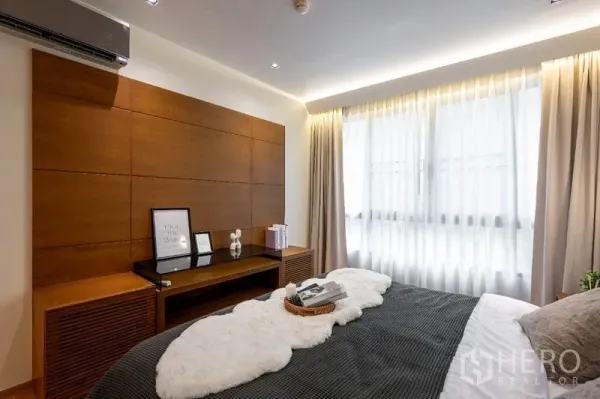 Condominium for sale - Second bedroom with wood panel accent wall, desk and wide window.
