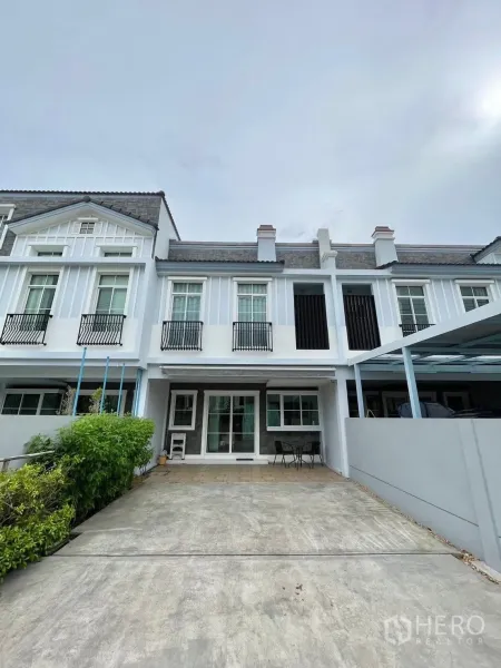 ทาวน์เฮาส์ for rent in Prawet, Bangkok - ด้านหน้าทาวน์เฮ้าส์สองชั้นสไตล์โมเดิร์นพร้อมพื้นที่จอดรถและมุมระเบียงเล็กๆ