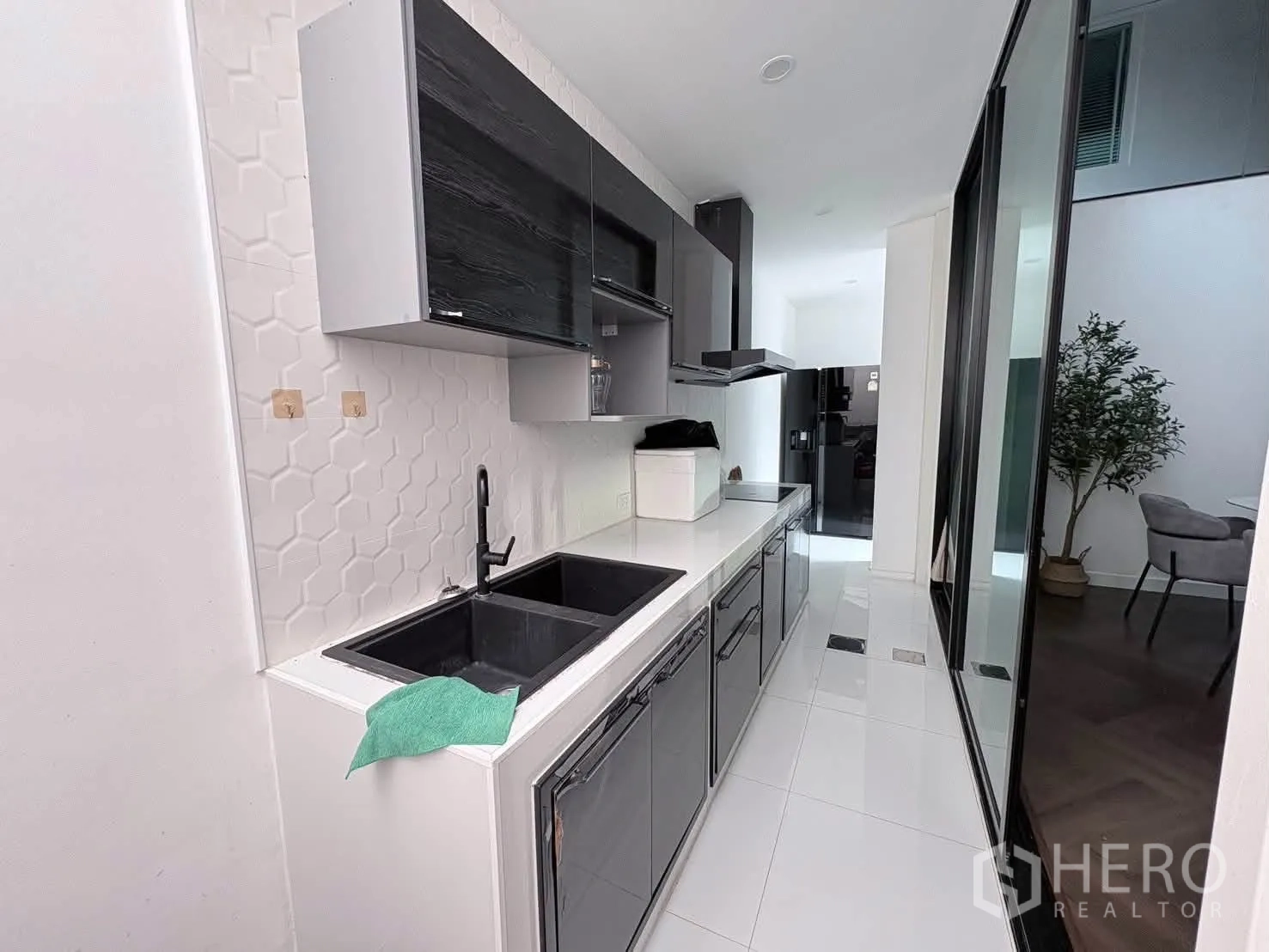 独栋房屋 for rent in Saphan Sung, Bangkok - 走廊式厨房，黑色水槽、灶台、抽油烟机与亮面橱柜。