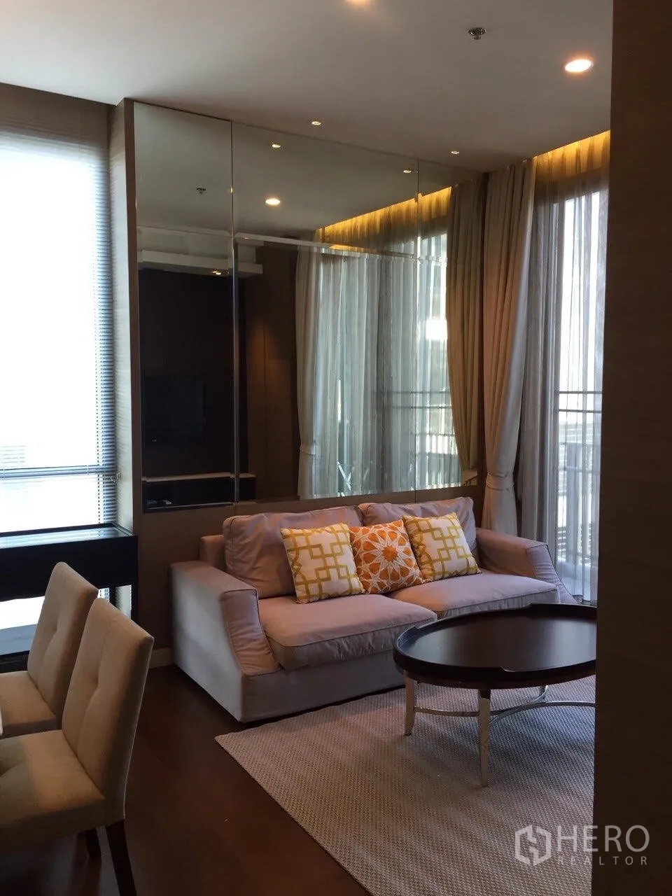 คอนโด ให้เช่าในWatthana, Bangkok - ห้องนั่งเล่นสว่าง โซฟาพร้อมหมอนลาย โต๊ะกลางทรงกลม และหน้าต่างเต็มบานพร้อมผ้าม่าน